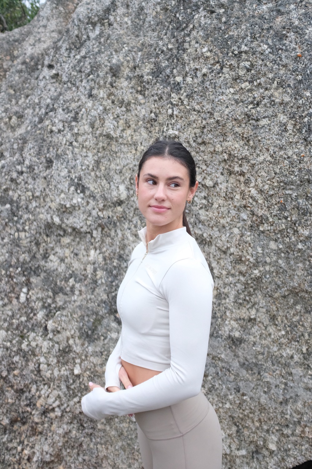 Rebekah in warm light against coastal stone